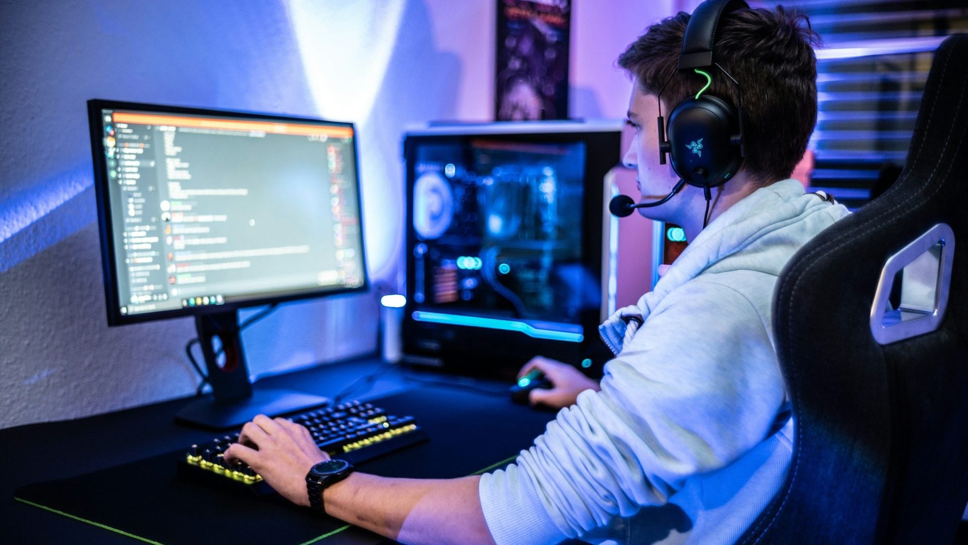 a man wearing a headset sitting at a computer desk